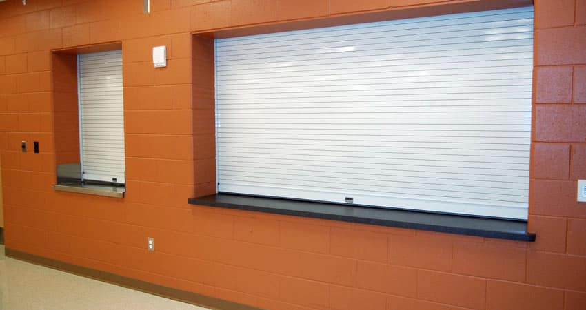 Picture of an orange wall with a silver security shutter.